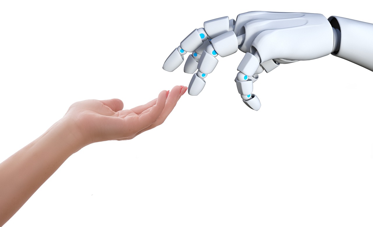 Main humaine et main robotique qui se rejoignent