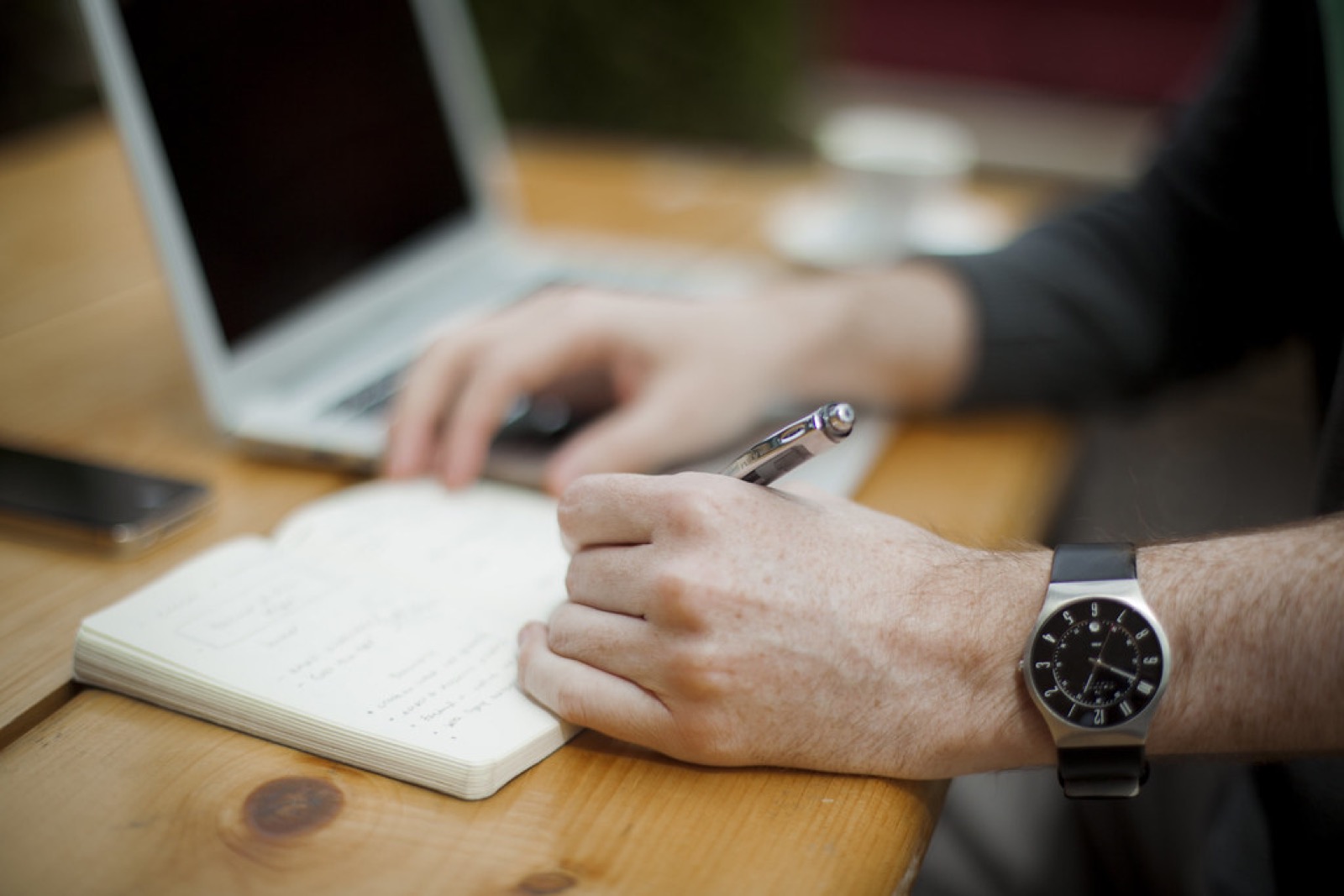 Rédaction d'un article, prise de notes à côté d'un ordinateur
